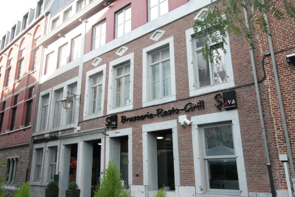 un edificio de ladrillo con un cartel en la parte delantera en Amosa Liège City Centre Hotel en Lieja