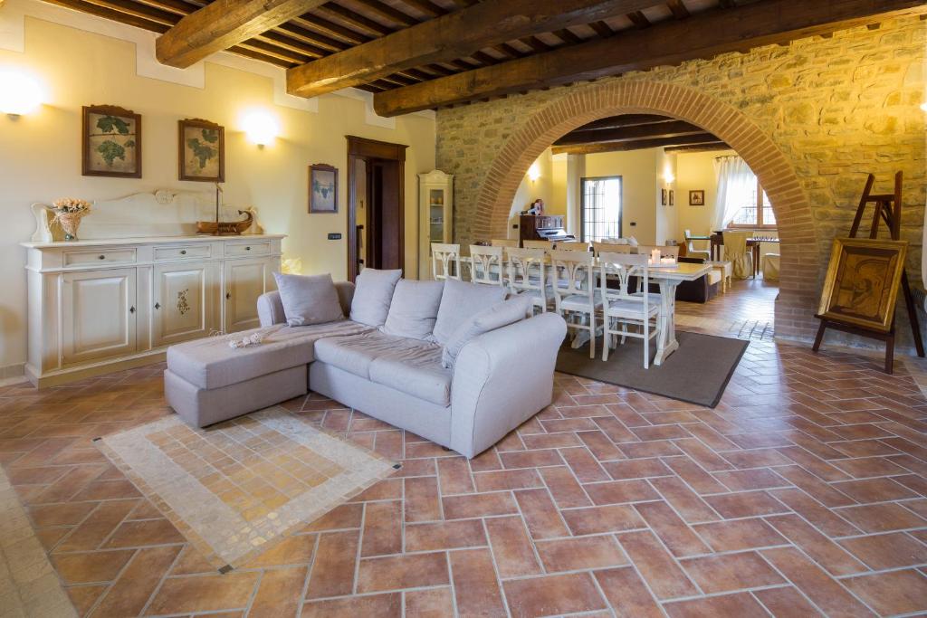 ein Wohnzimmer mit einem Sofa, einer Küche und einem Tisch in der Unterkunft Villa dei Tramonti in Passignano sul Trasimeno