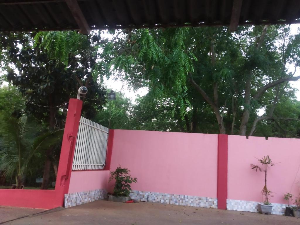 a pink fence with trees in the background at pousadavaledasaguas in Foz do Iguaçu