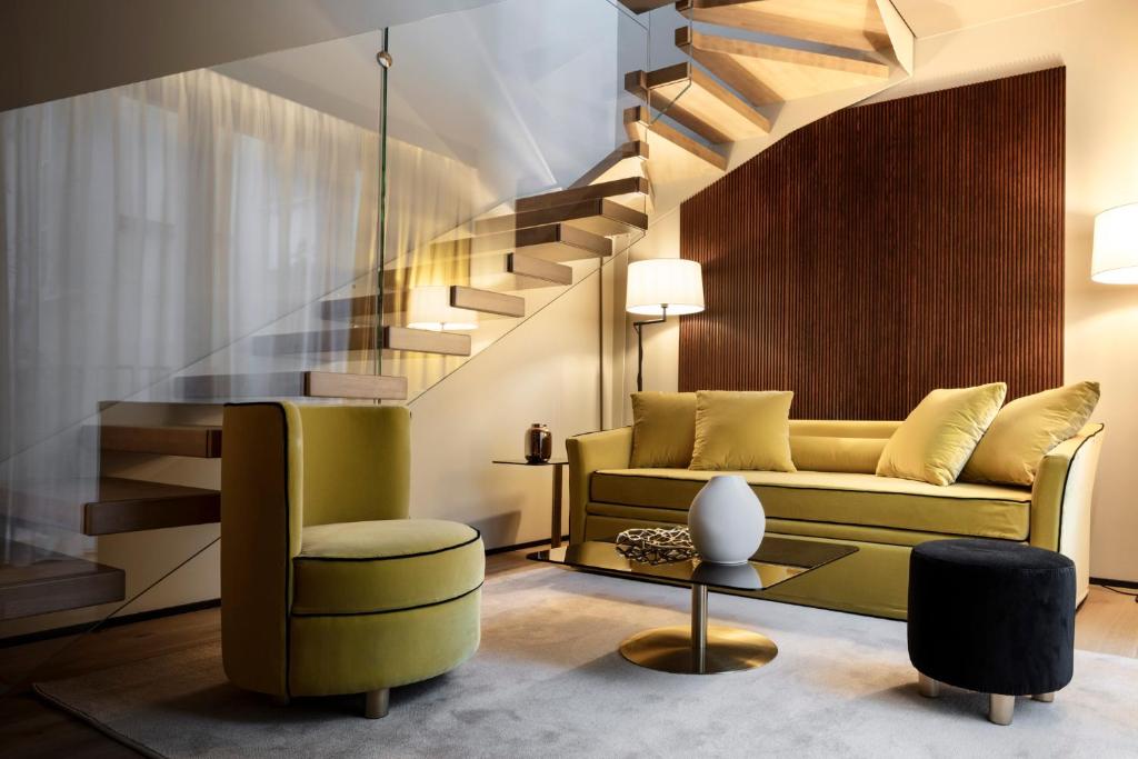 uma sala de estar com um sofá amarelo e escadas em Speronari Suites em Milão