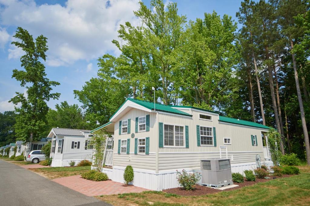 ein weißes Haus mit grünem Dach in der Unterkunft Bethpage Hewick Three-Bedroom Cottage 30 in Urbanna