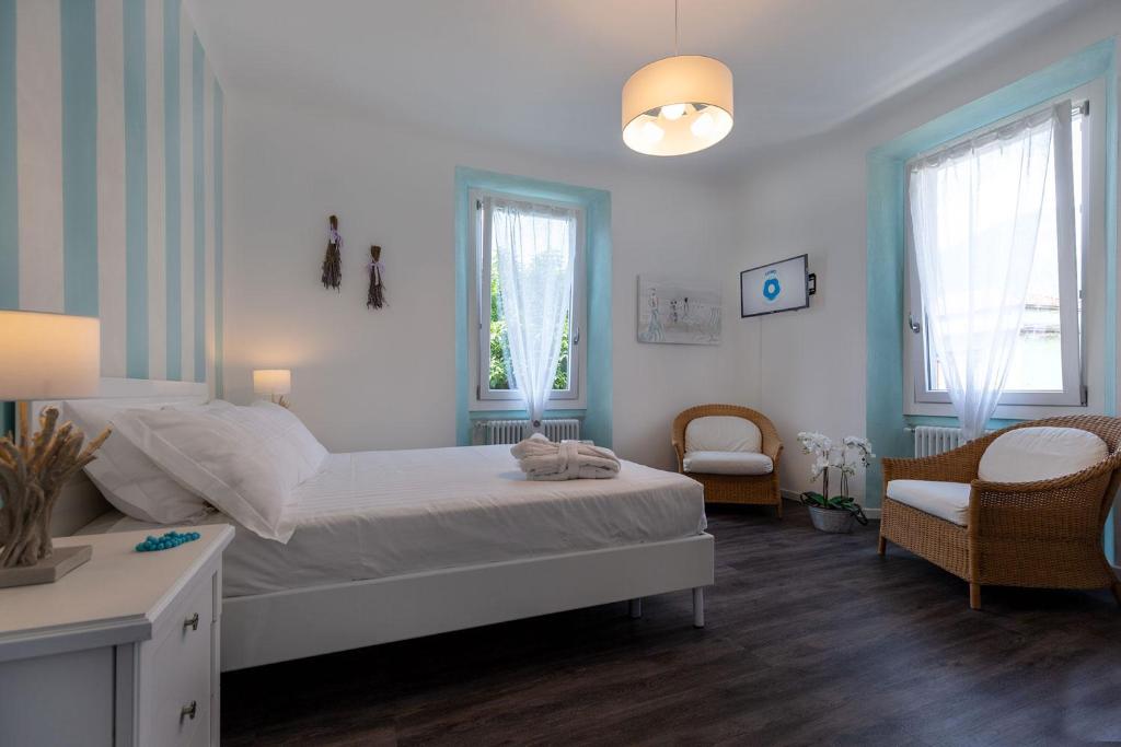 a bedroom with a bed and a chair and windows at Maji Como Lake in Mandello del Lario