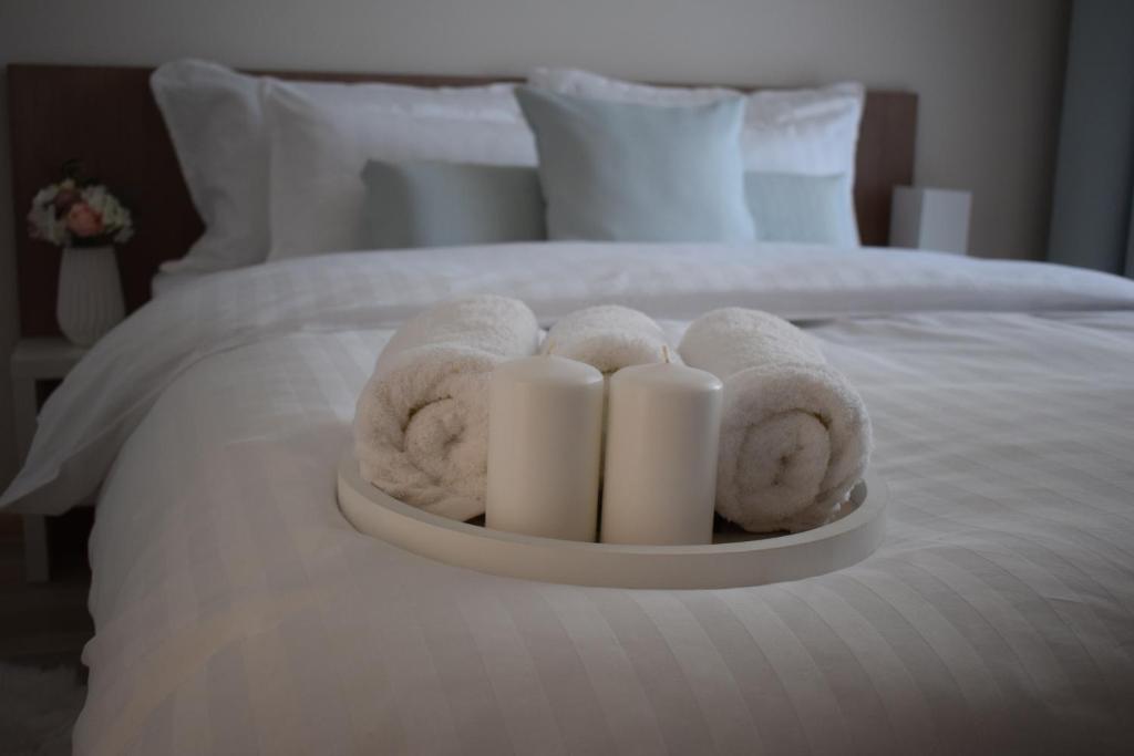 a tray of towels and candles on a bed at Sweet Residence Apartment in Arad