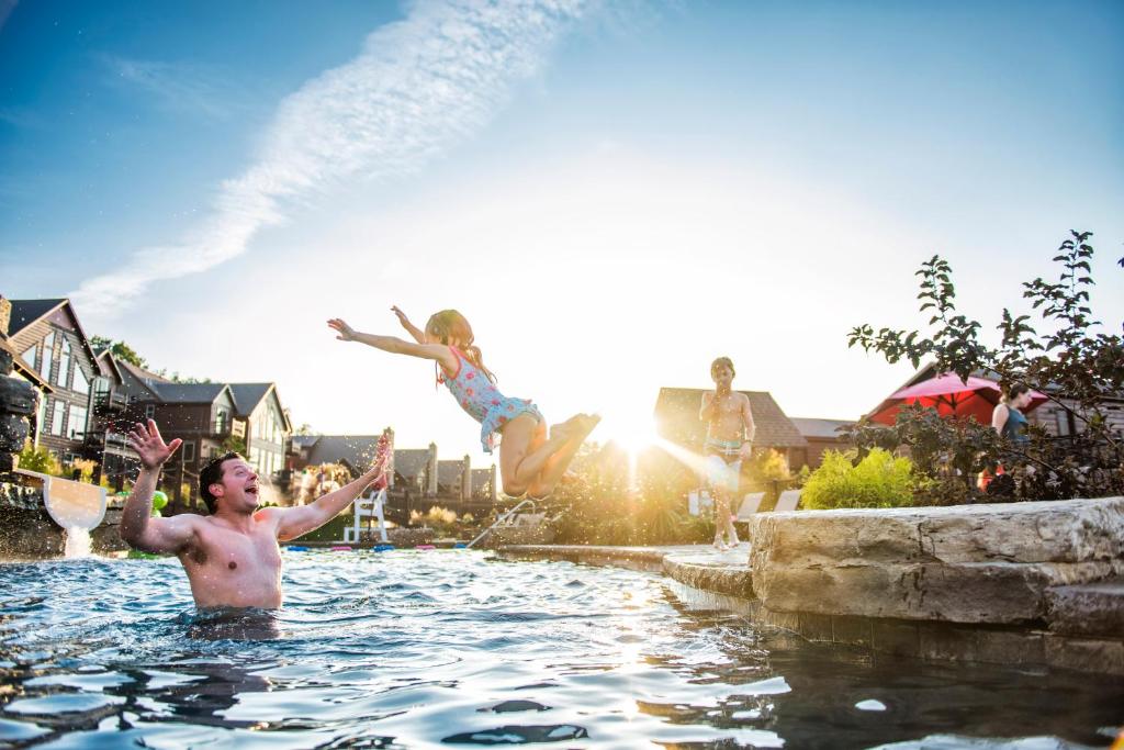 duas pessoas a saltar para uma piscina em WaterMill Cove Resort Luxury Lakefront Villa By Silver Dollar City MiniGolf POOL Kayaks em Branson