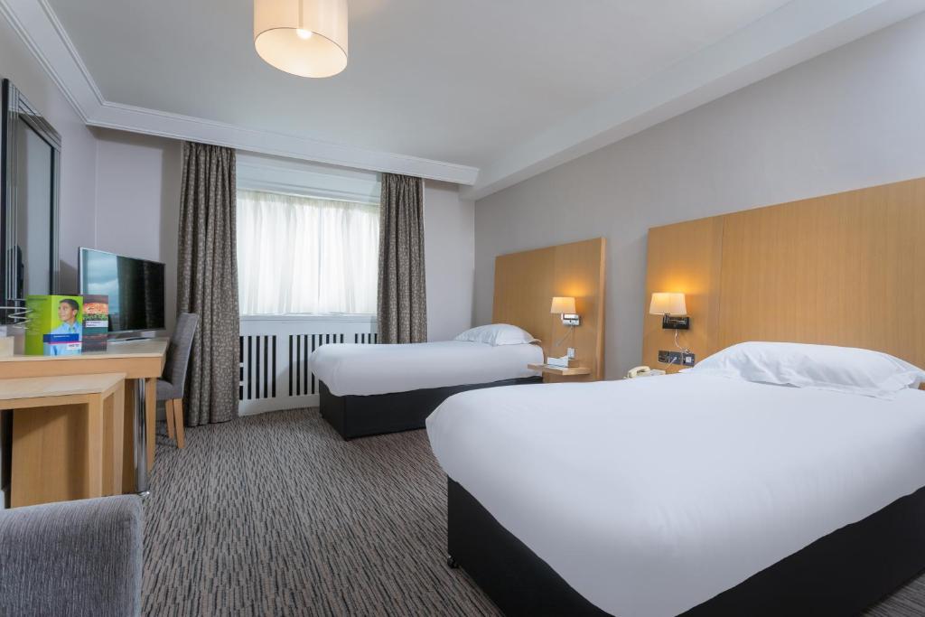 a hotel room with two beds and a television at Park Inn by Radisson Shannon Airport in Shannon