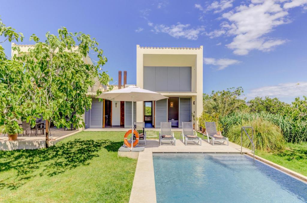 a villa with a swimming pool and a house at Villa Vertent by Sealand Villas in Alcudia