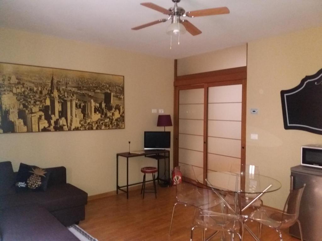 a living room with a ceiling fan and a glass table at Suite Saragozza Free small Parking,Bologna in Bologna