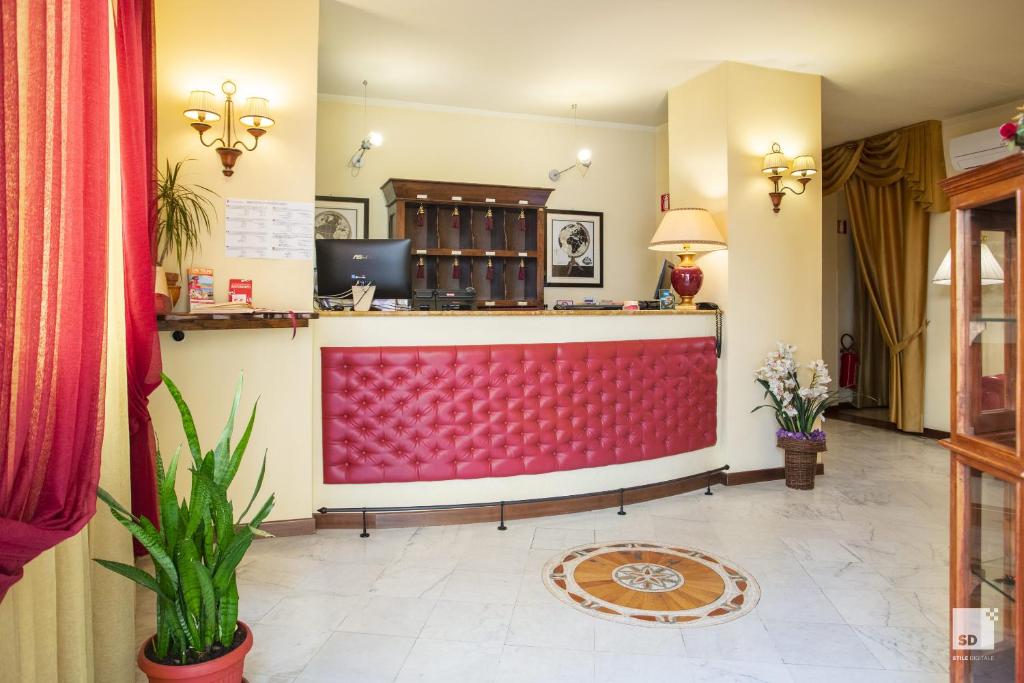 a lobby of a hotel with a red counter at Hotel Alessandro Della Spina in Pisa