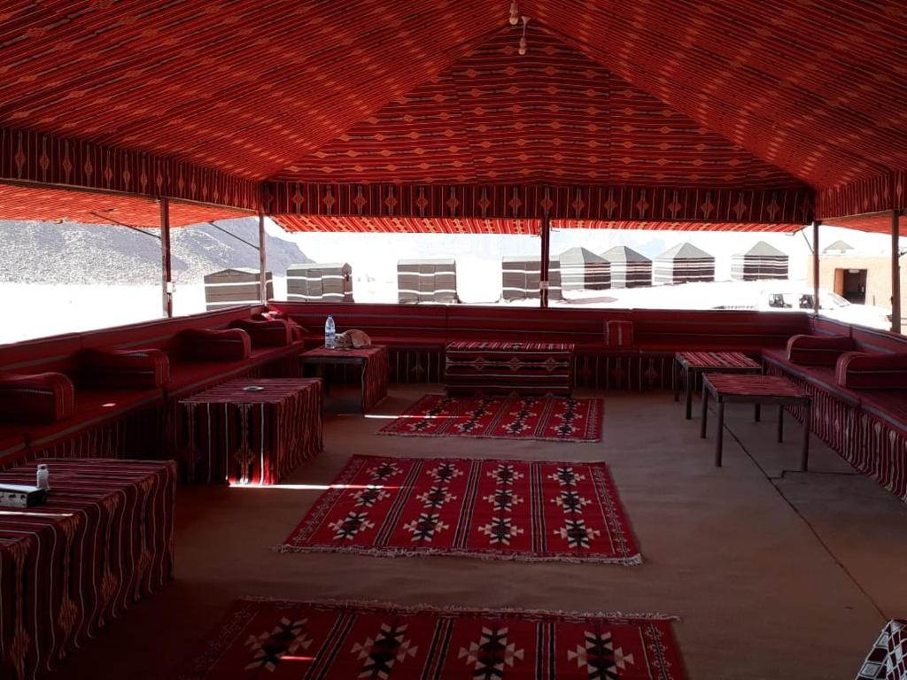 a large room with red tables and red carpets at Wadi rum desert breath in Wadi Rum