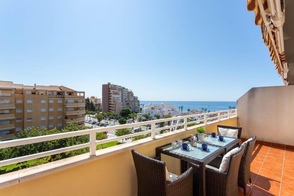 阿爾加羅沃的住宿－Dúplex Algarrobo Costa，一个带桌椅的海景阳台