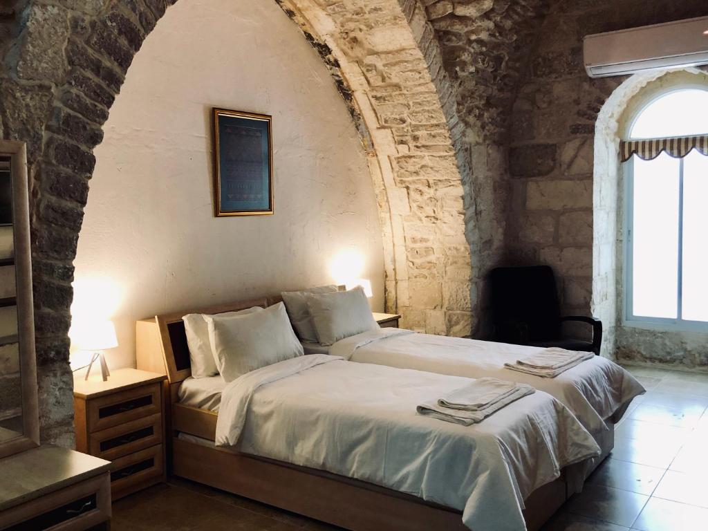 - une chambre avec un grand lit dans un mur en pierre dans l'établissement Christian Quarter Studio I, à Jérusalem
