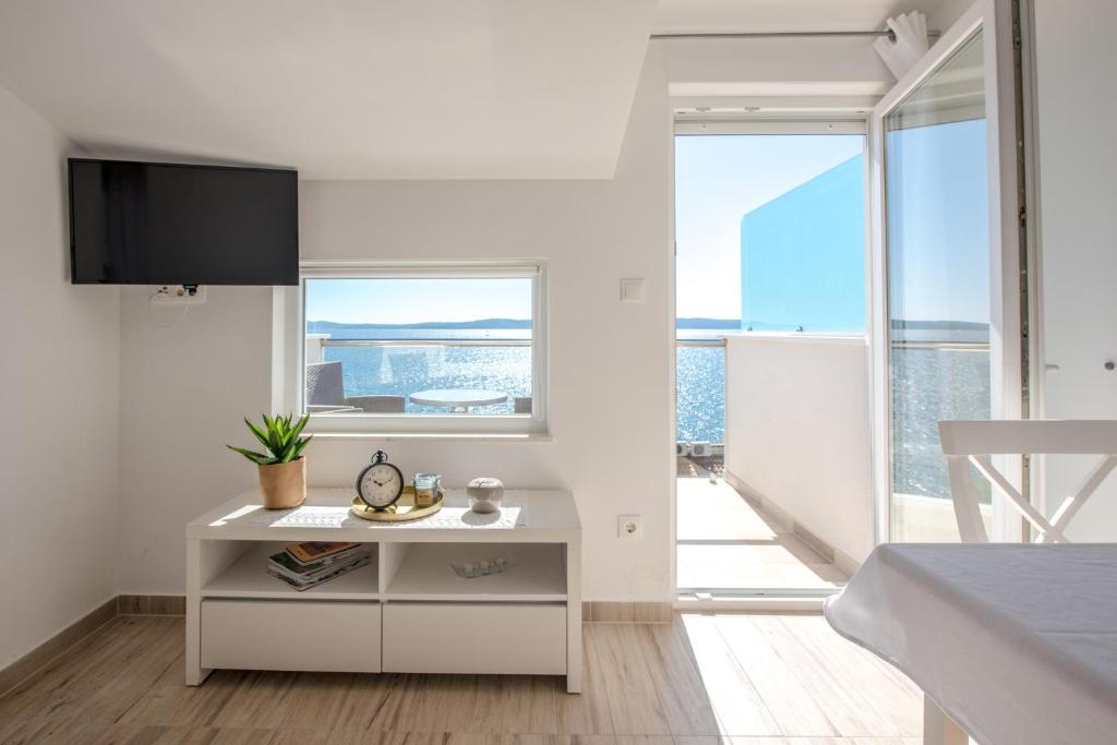 un soggiorno bianco con TV a parete di Apartments Amneris a Trogir