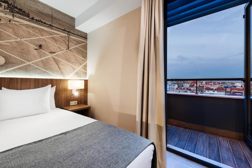 A bedroom corner with a large glazed opening overlooking Lisbon rooftops.