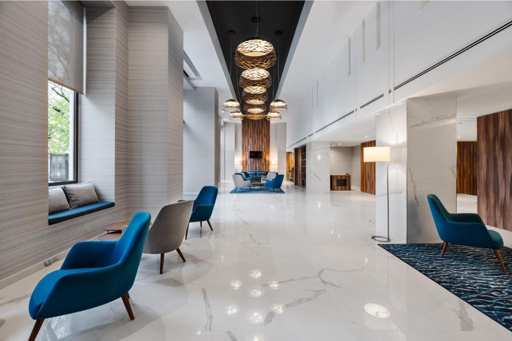 A bright, spacious lobby lounge with blue and grey seating.
