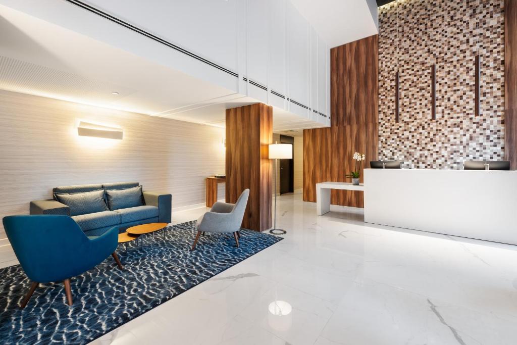 A reception-facing lounge with a blue sofa and armchairs beside the front desk.