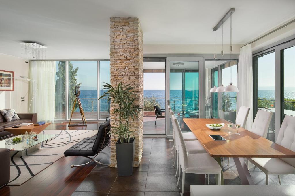 jadalnia ze stołem i krzesłami oraz oceanem w obiekcie Villa Arentz Residence - Front Sea Apartments w mieście Opatija