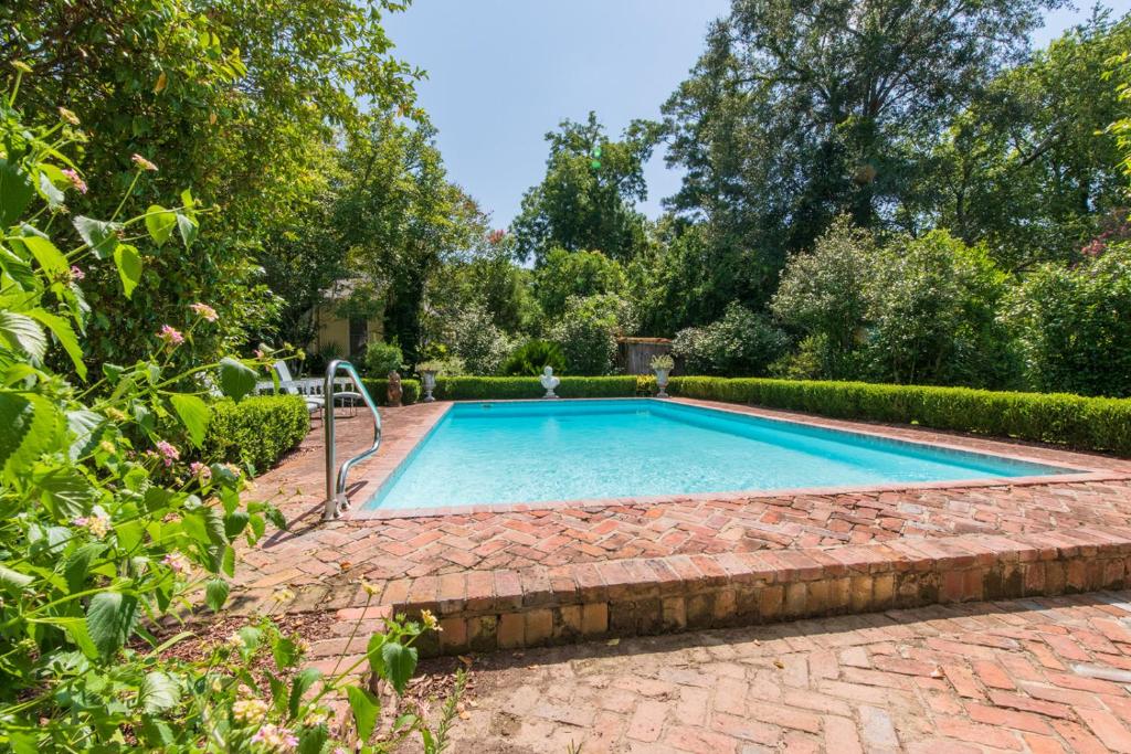 a swimming pool in a garden with a brick walkway at The Burn Bed and Breakfast in Natchez