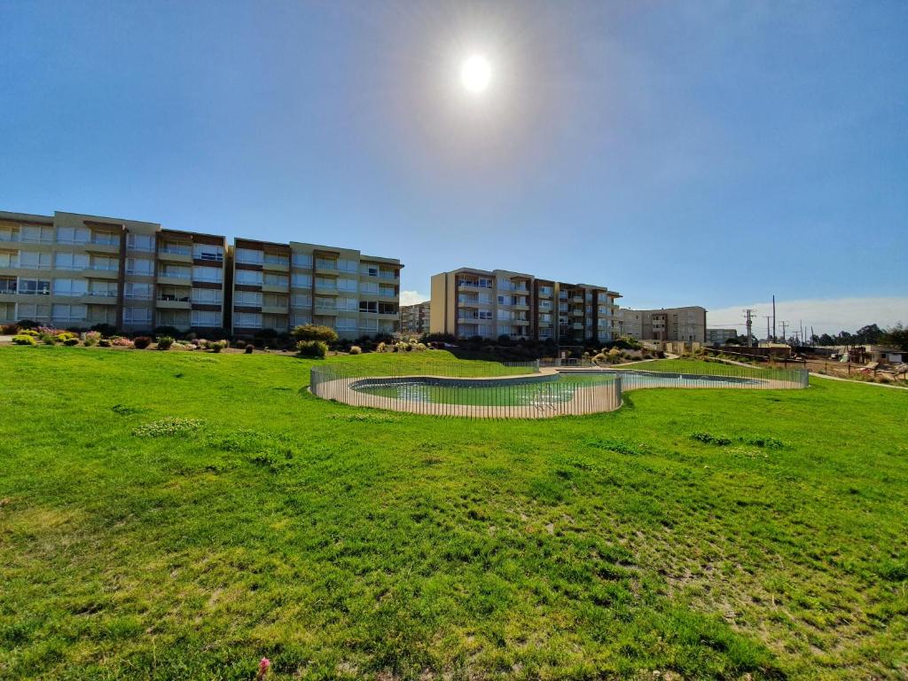 um parque com piscina no meio de um campo em Departamento en Lomas de Papudo V em Papudo