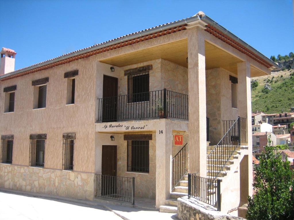 un edificio de piedra con una escalera delante en APARTAMENTOS Y HABITACIONES RURALES "El Corral", en Cañizares