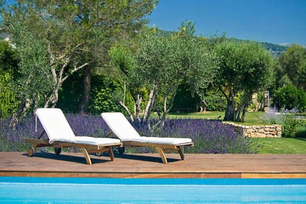 トゥレット・シュル・ルーにあるLa Lavandeのスイミングプールの隣に白い椅子2脚