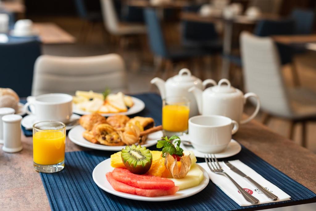 A plated continental breakfast with fruit, pastries, juice, tea and coffee.