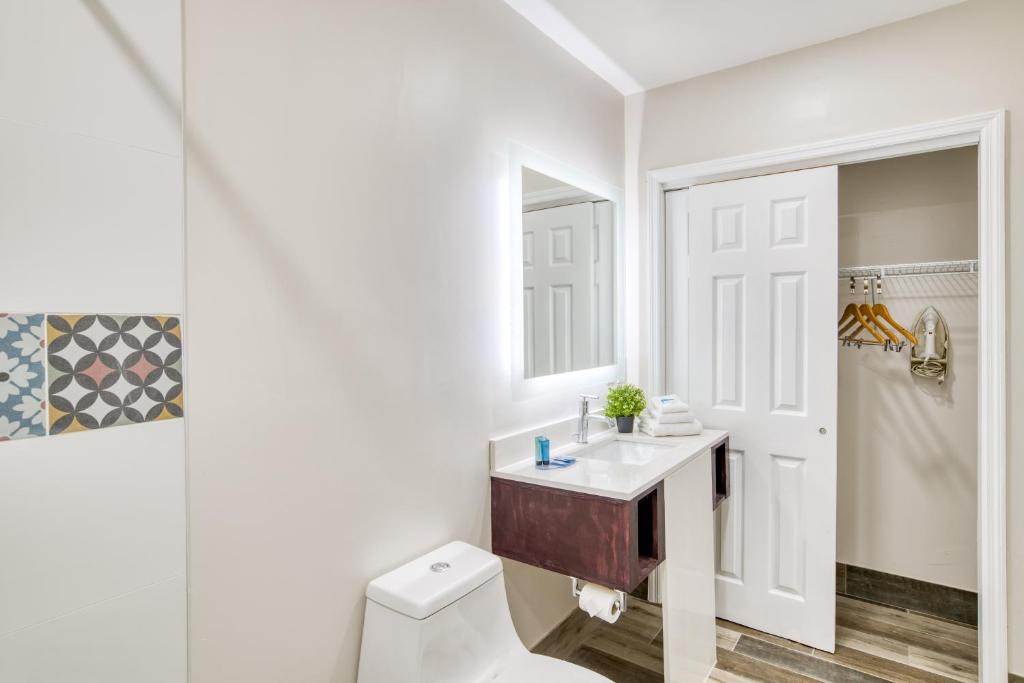 ein Badezimmer mit Toilette, Waschbecken und Spiegel in der Unterkunft Villa 1565 - Saint Augustine in St. Augustine