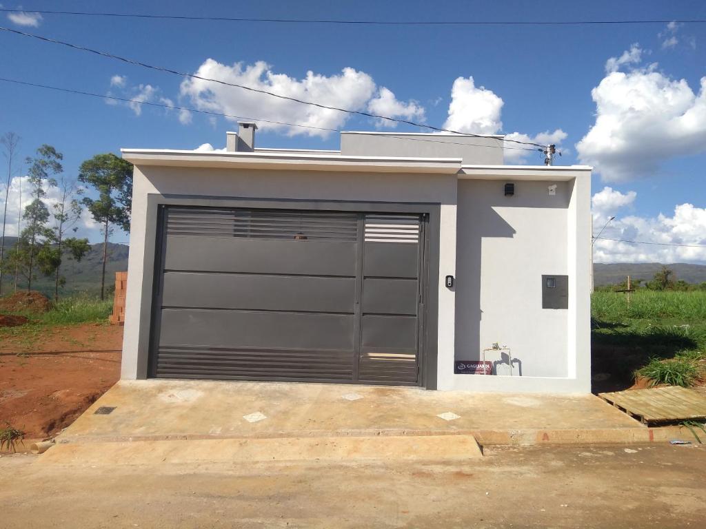 uma garagem com uma grande porta ao lado em Casa da Canastra em Delfinópolis