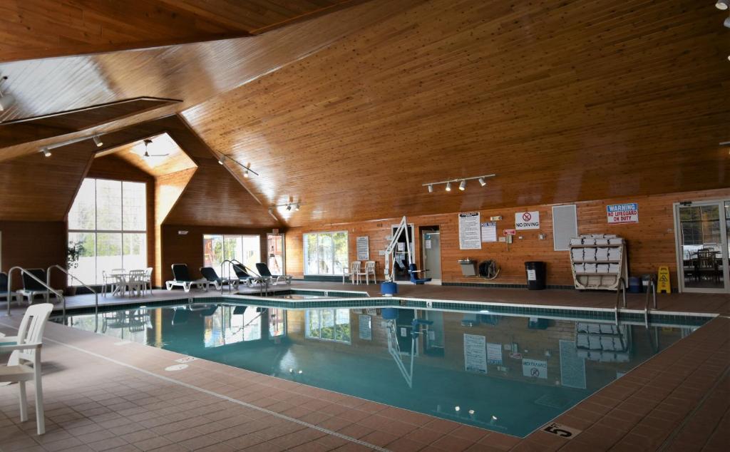 a large swimming pool in a building with a wooden ceiling at Pheasant Park Resort in Sister Bay
