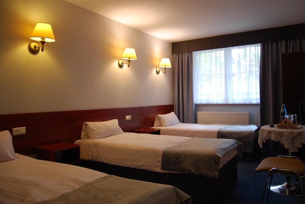 Postel nebo postele na pokoji v ubytování Amigo Hotel