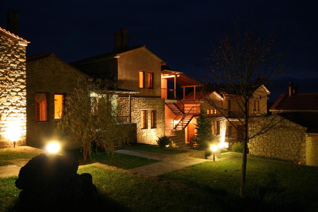 a person sitting in front of a house at night at Amadryades Boutique Hotel in Alatopetra