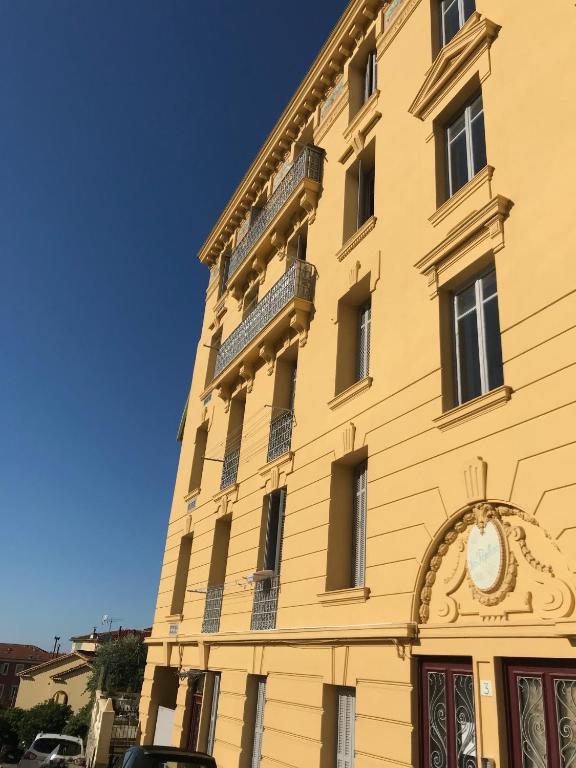 a yellow building with a clock on the side of it at Beau 3 pieces proche centre in Menton
