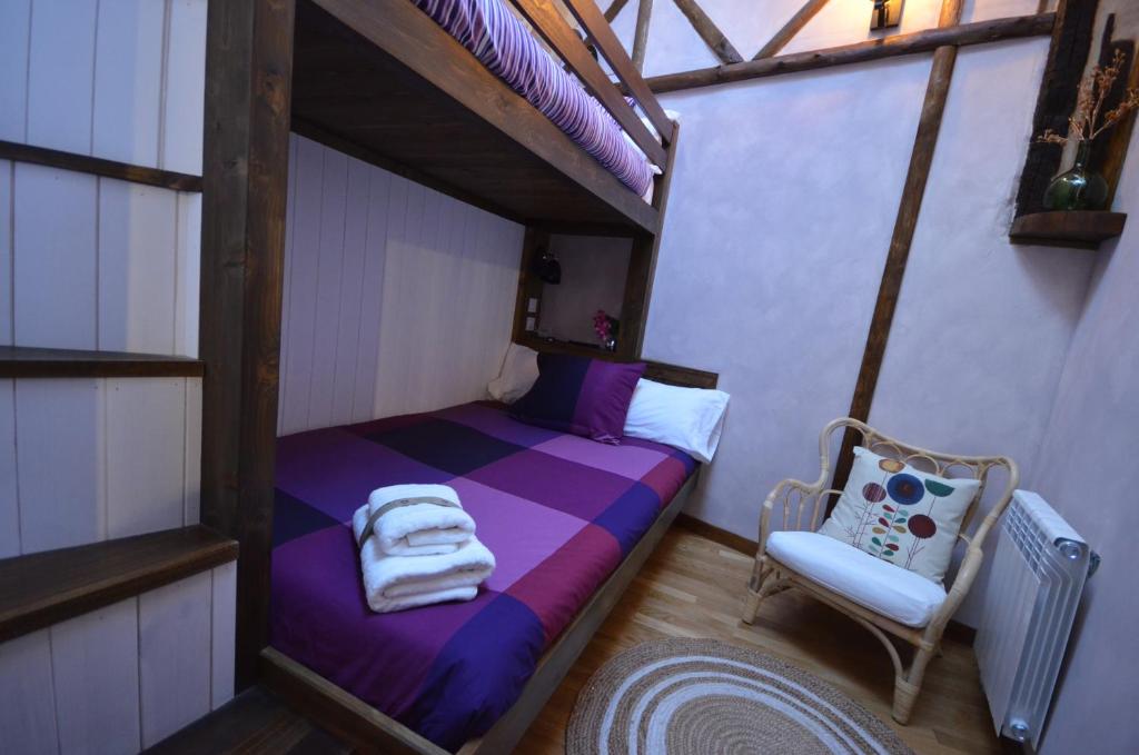 a small bedroom with a bed and a chair at El Balcon de Justina - Sierra de Gata in Torre de Don Miguel
