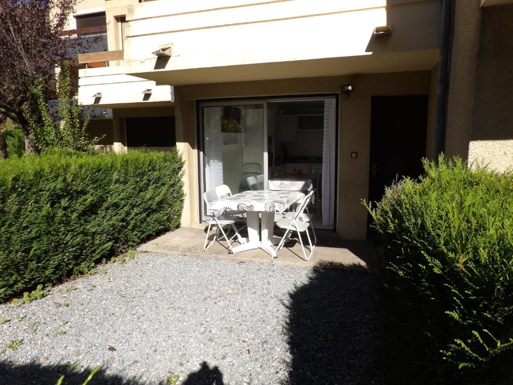 a table and chairs sitting outside of a house at Hameau des Thermes - appartement rez de chaussée in Saint-Lary-Soulan