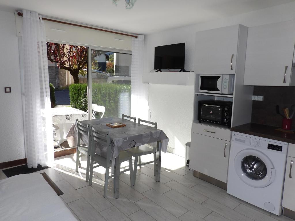 cocina con mesa y lavadora en Hameau des Thermes - appartement rez de chaussée en Saint-Lary-Soulan