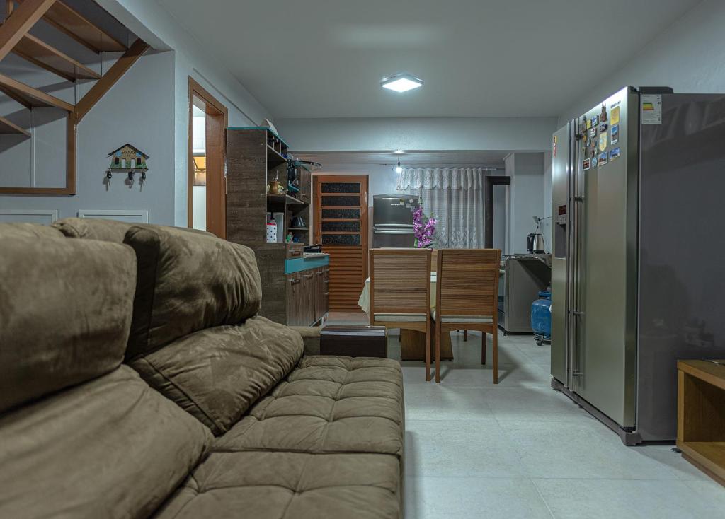 ein Wohnzimmer mit einem Sofa und einer Küche in der Unterkunft Apartamento Completo de 2 quartos em Gramado in Gramado