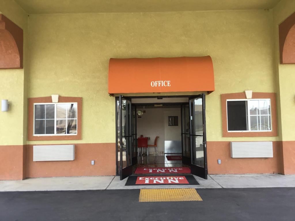 an entrance to a building with an orange awning at Executive Inn westley,CA in Westley