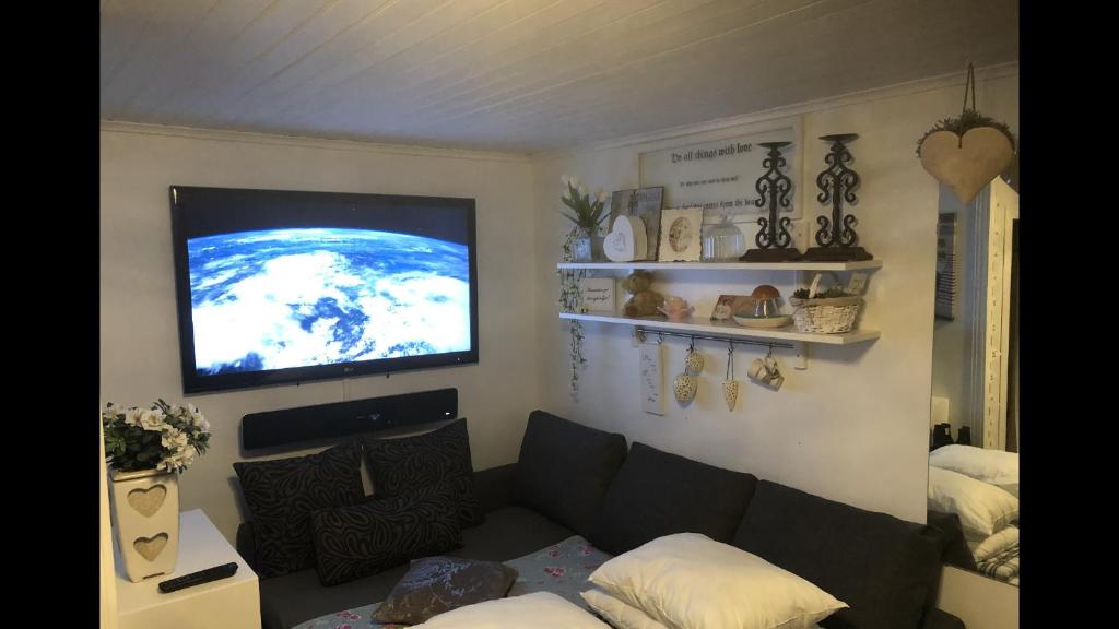 a living room with a couch and a flat screen tv at Villa Lillgården with Sauna and Jacuzzi in Norrköping