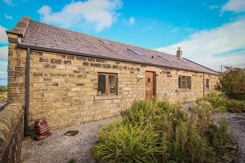 un piccolo edificio in mattoni con una finestra sopra di Foxhill Fold a Gisburn