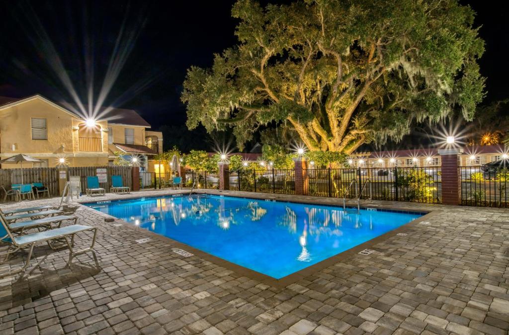 ein Schwimmbad in der Nacht mit einem Baum und Lichtern in der Unterkunft Villa 1565 - Saint Augustine in St. Augustine