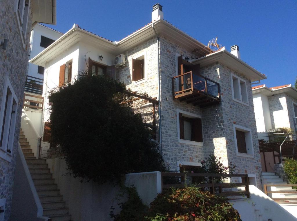 biały ceglany dom z balkonem i schodami w obiekcie AUTUMN TO SUMMER w mieście Agios Ioannis Pelio