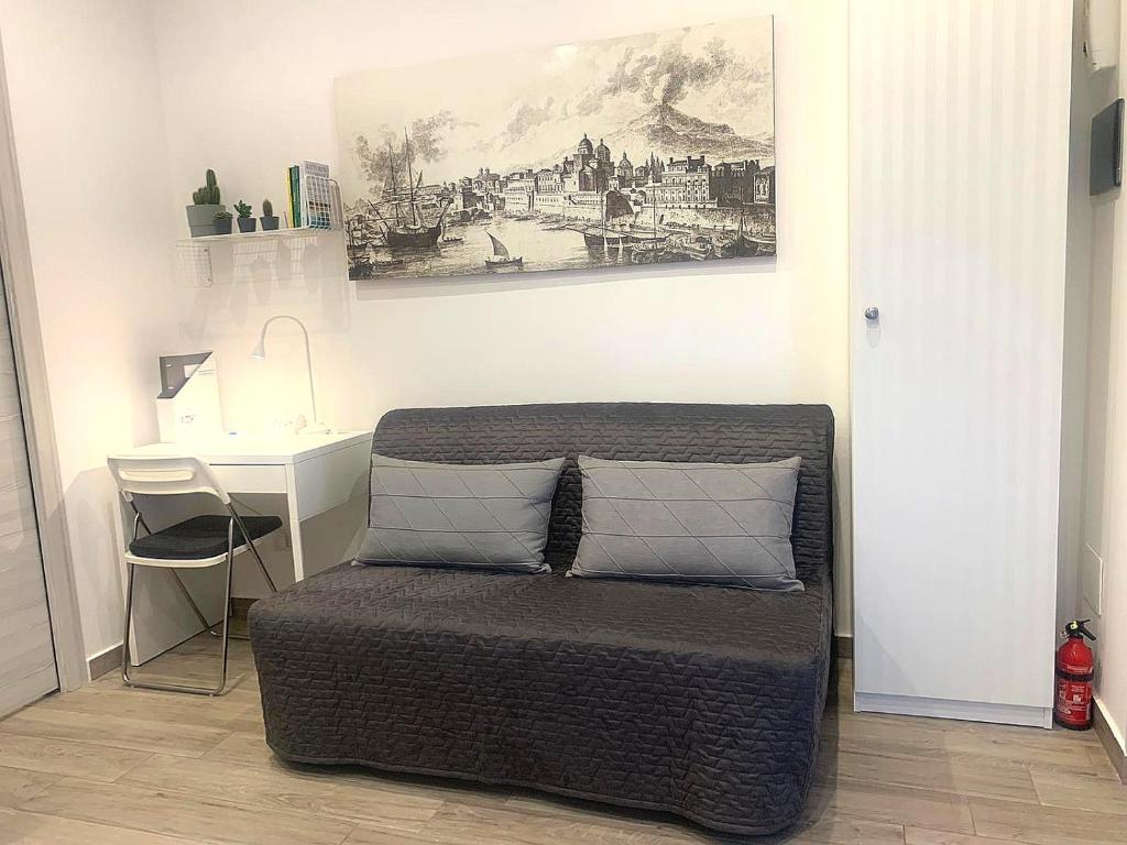 łóżko z 2 poduszkami i biurkiem w pokoju w obiekcie CATANIA CENTRAL DELUXE HOUSE w Katanii