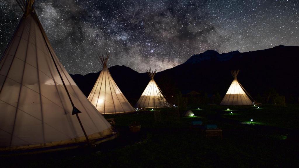 a group of tents at night under a starry sky at Dreamcatcher Tipi Hotel in Gardiner