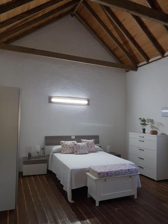 sypialnia z białym łóżkiem i drewnianą podłogą w obiekcie Siempreviva w mieście Las Palmas de Gran Canaria