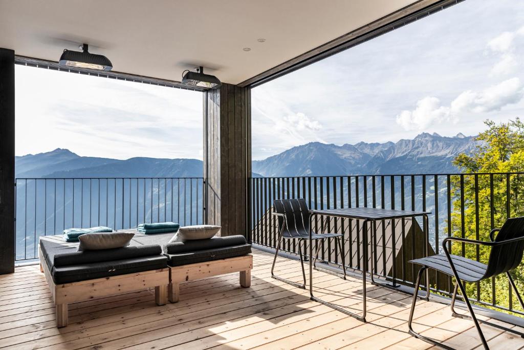 a balcony with a couch and a view of mountains at Miramonti Boutique Hotel in Avelengo