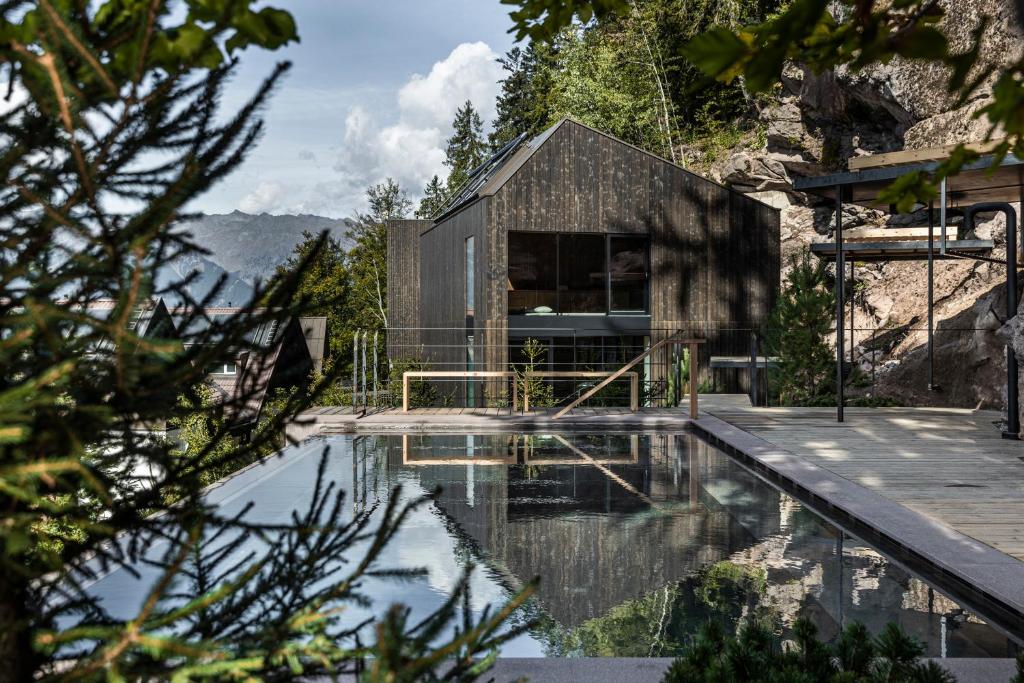 a house on the side of a mountain with a swimming pool at Miramonti Boutique Hotel in Avelengo