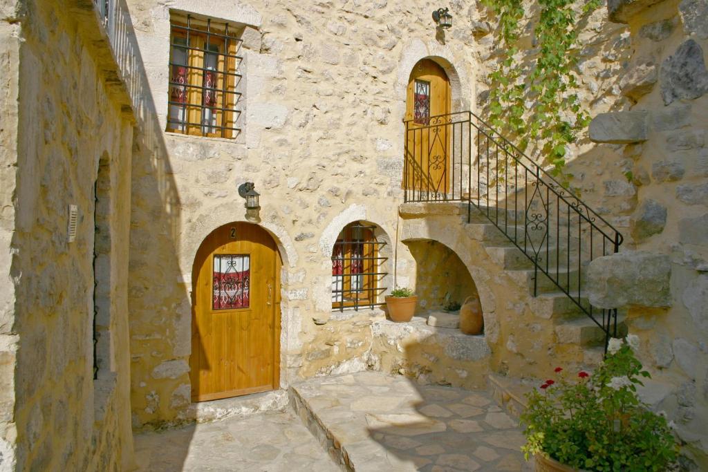 an old stone building with a wooden door and stairs at Vafes Traditional Stone Houses in Vafés