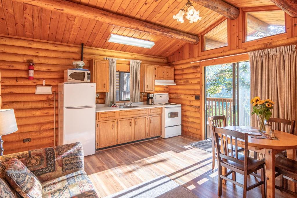a kitchen and dining room with a table in a cabin at Cusheon Lake Resort in Ganges