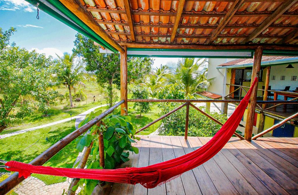 a hammock on a porch of a house at Fazenda Eco-Jardim in Una
