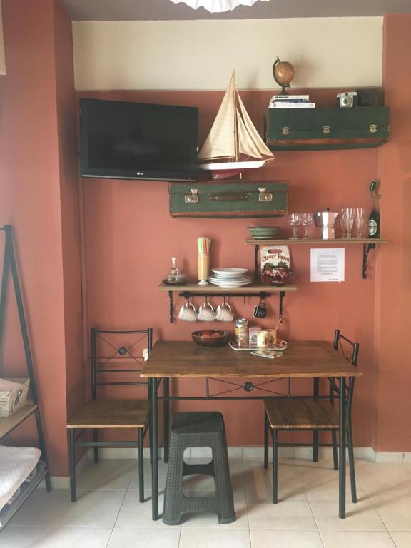 une salle à manger avec une table et des étagères en bois dans l'établissement Cozy Little Home, à Héraklion