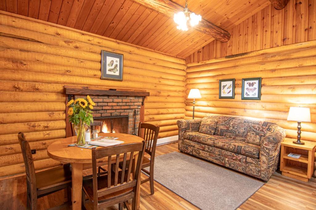 a living room with a table and a couch and a fireplace at Cusheon Lake Resort in Ganges